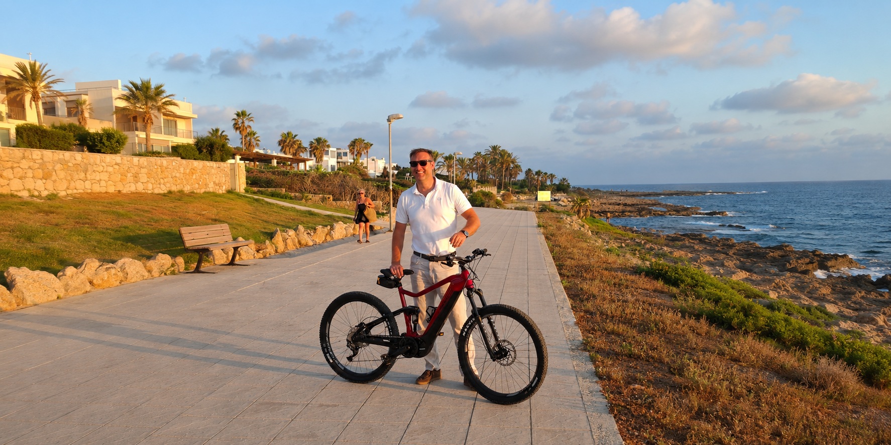 Adam Bisaggio z BiRide z rowerem elektrycznym na nadmorskiej promenadzie w Pafos na Cyprze
