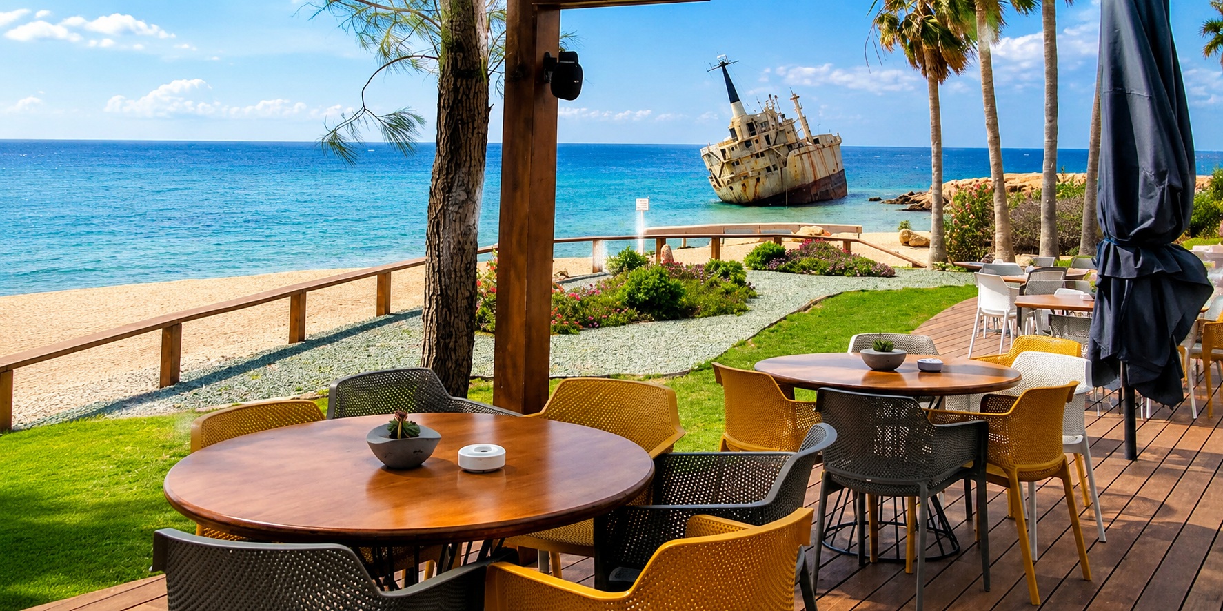 Seaside café terrace overlooking the Edro III Shipwreck on the BiRide e-bike route near Coral Bay and Sea Caves