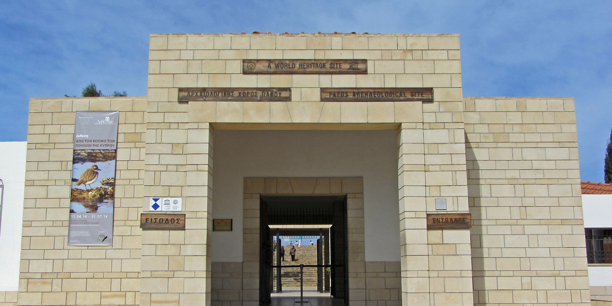Entrance to Kato Paphos Archaeological Park displaying the World Heritage Site emblem near Paphos Castle and Harbour